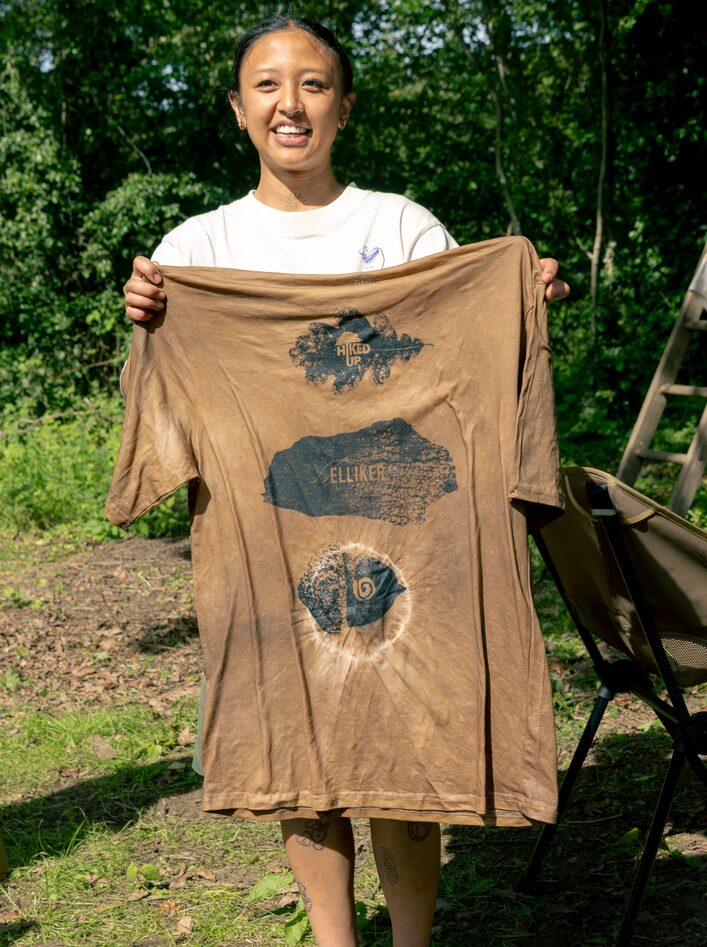 Nana Frank holding up Natural Dyed ELLIKER Tshirt